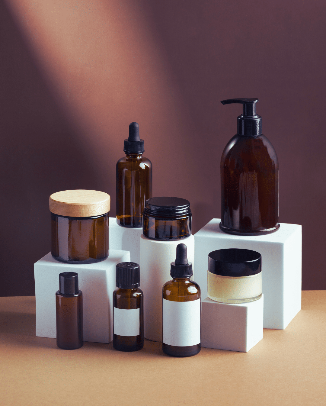 Une composition minimaliste de produits cosmétiques sans étiquettes, mettant en avant leur forme et leur texture de manière neutre et élégante.